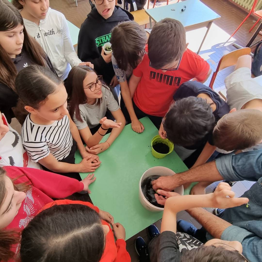 Alunni e ragazzi riuniti attorno a un tavolo durante i laboratori esperienziali a Novara all'interno delle scuole, mentre scoprono l'idroponica e le interconnessioni psicofisiche del Metodo C.A.M.